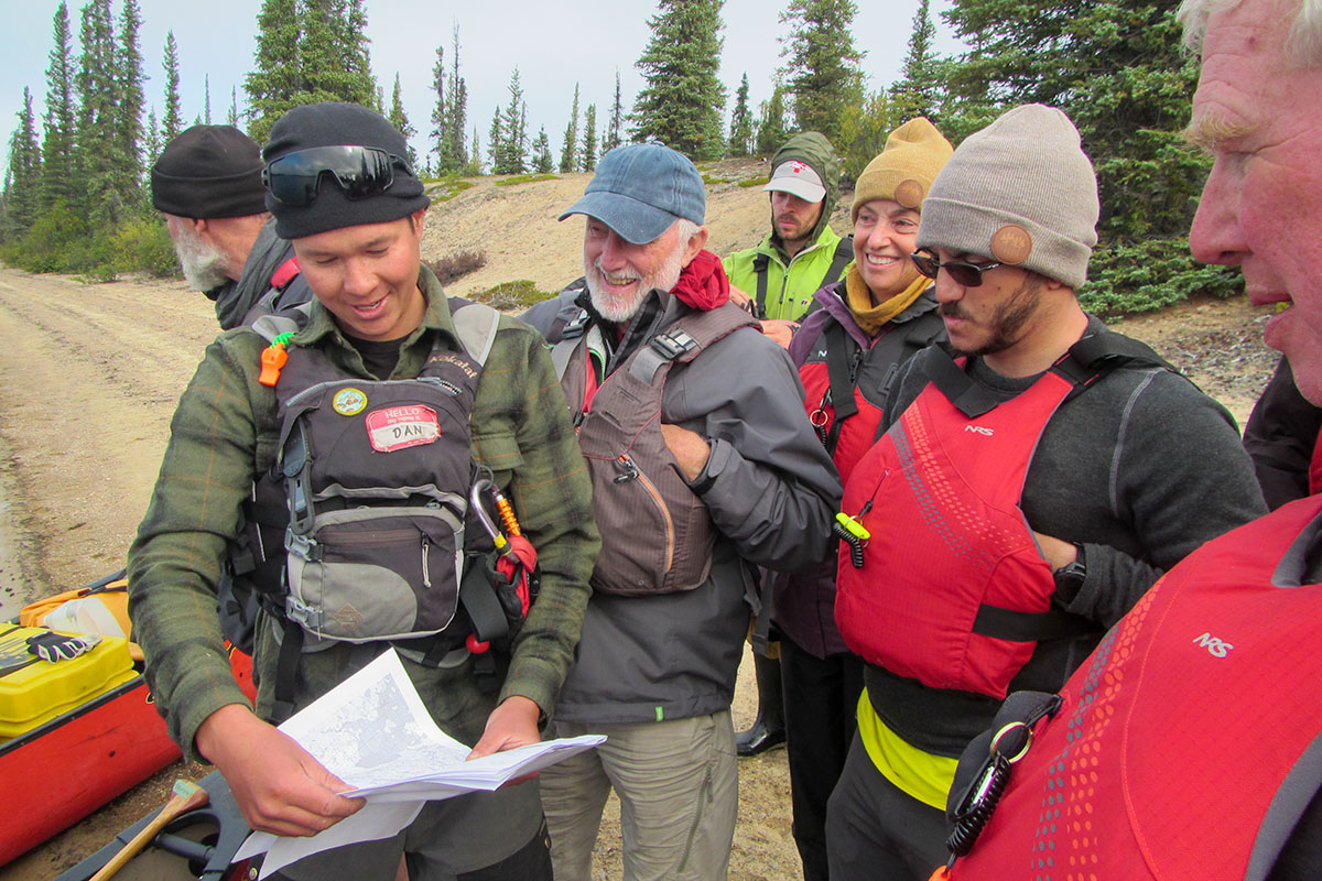 a canoe guide in the northwest territories showing people a map