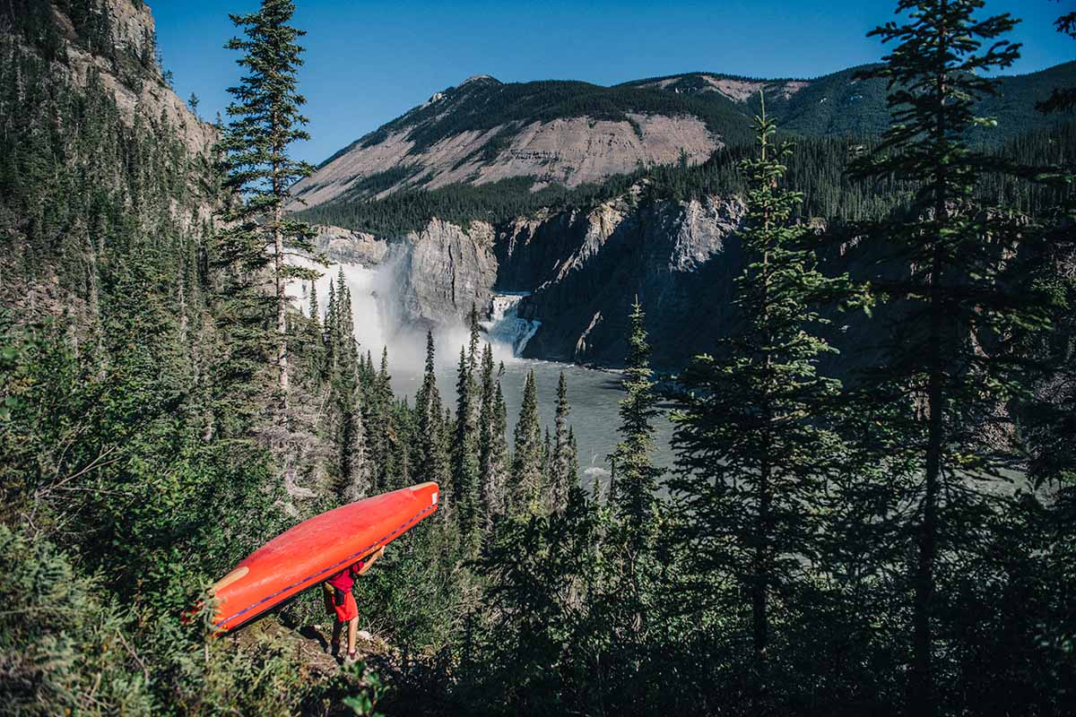 guide portaging a canoe around virginia falls, a map